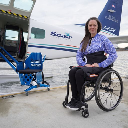 Woman sitting in wheelchair, next to seaplane with a mobility lift Woman sitting in wheelchair, next to seaplane with a mobility lift